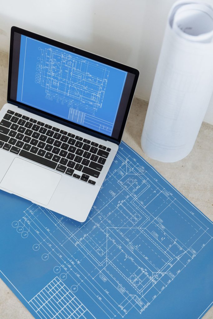 Ordinateur portable affichant un plan de bâtiment sur un bureau, pour illustrer la continuité des logiciels de gestion du BTP